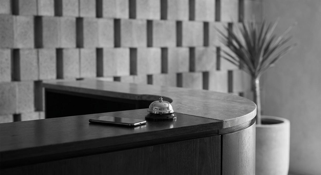 Abstract grayscale composition of a hotel reception with a phone and a bell